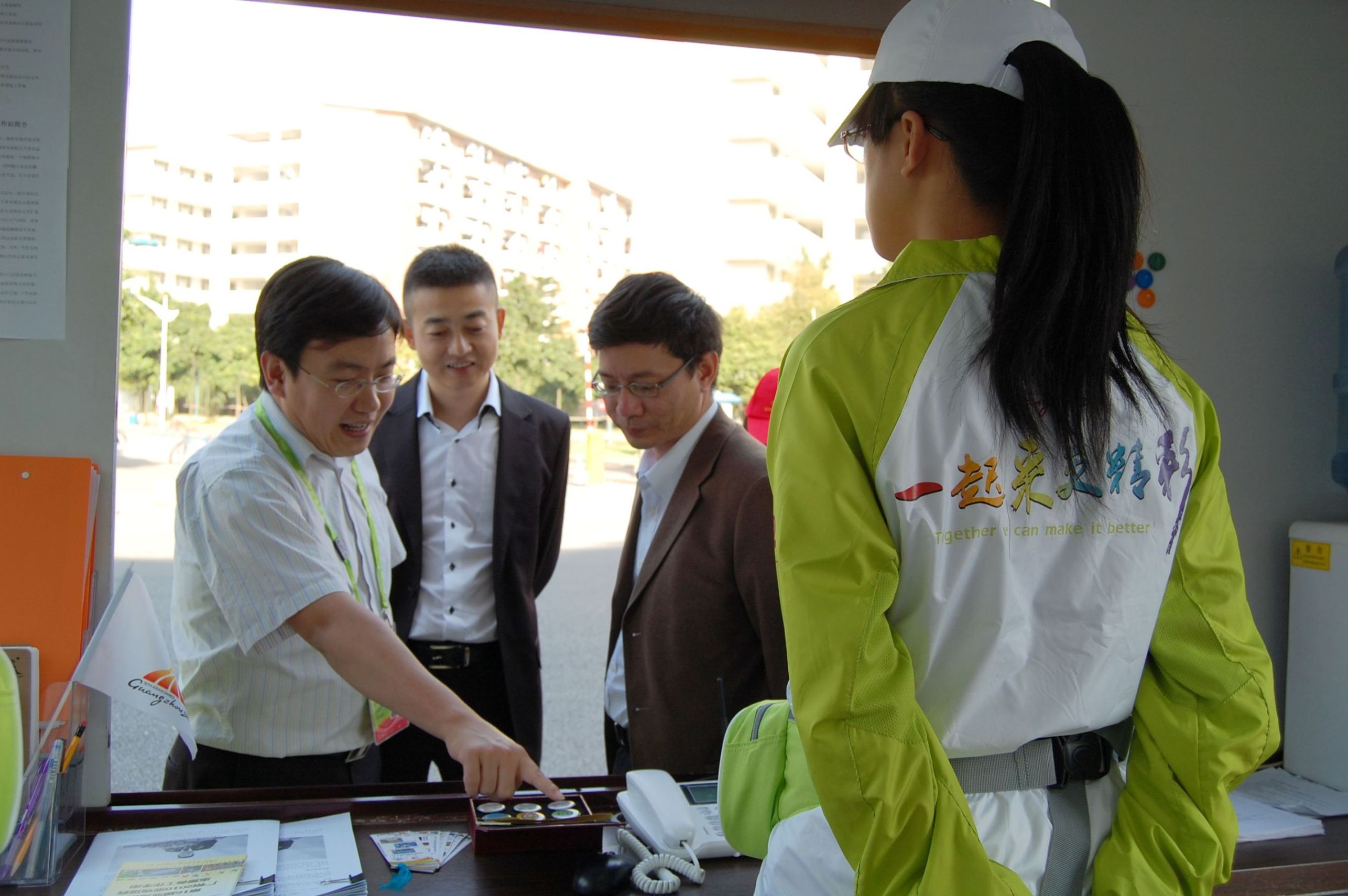 刘志军向来宾介绍伟德bv国际体育亚运徽章